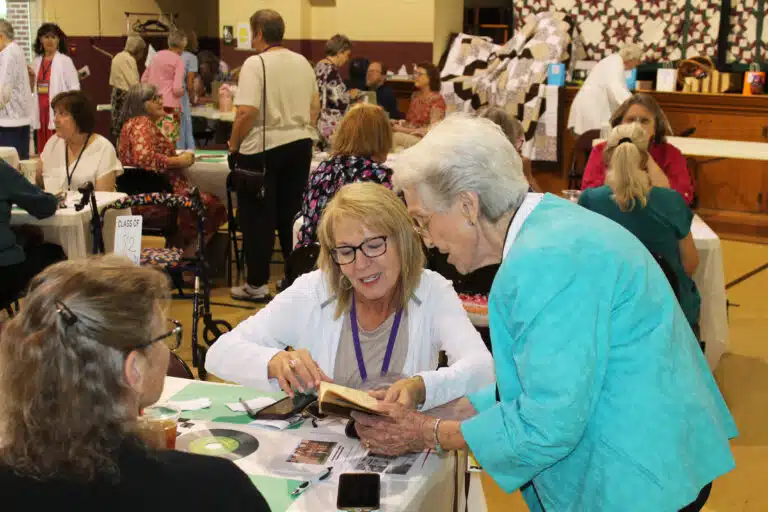 Carol Toon Clapp A’82, looks over a book with Sister Elaine Burke A’49. Carol Toon Clapp A’82, looks over a book with Sister Elaine Burke A’49.