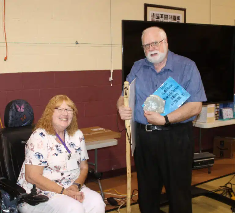 Father Ray Goetz holds an oversized card signed by alums, and a plaque with praying hands that was made by Brenda Basham Lee A’82, seated at left. Father Ray is retiring as the Mount chaplain after 16 years. Father Ray Goetz holds an oversized card signed by alums, and a plaque with praying hands that was made by Brenda Basham Lee A’82, seated at left. Father Ray is retiring as the Mount chaplain after 16 years.