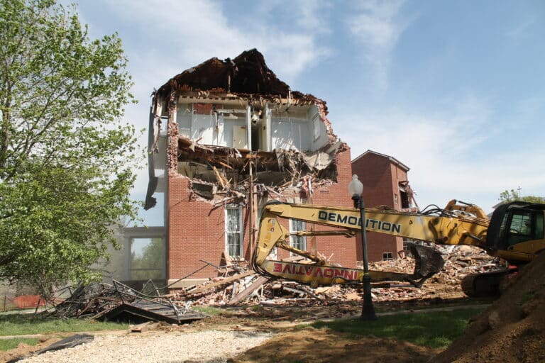 The 70-foot excavator began working on the 1904 addition to the building, stripping much of the west facing wall by the end of the day. The 70-foot excavator began working on the 1904 addition to the building, stripping much of the west facing wall by the end of the day.
