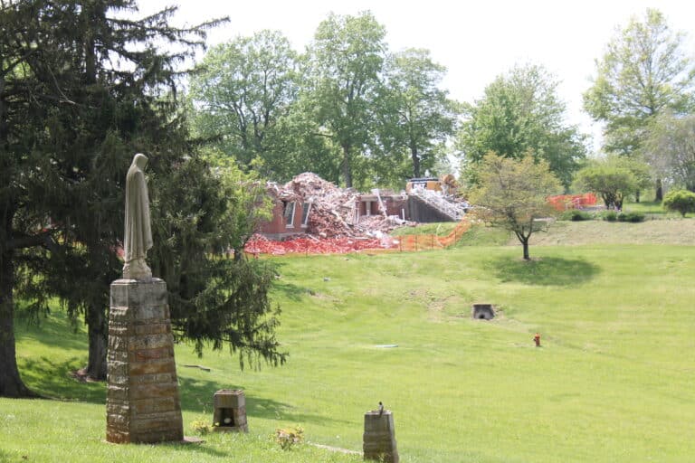The view of the deconstruction from the parking lot behind the Guest House, with the Our Lady of Fatima statue keeping watch.