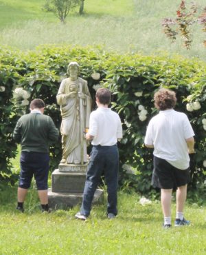 6th grade boys visit the statue of St. Jude.