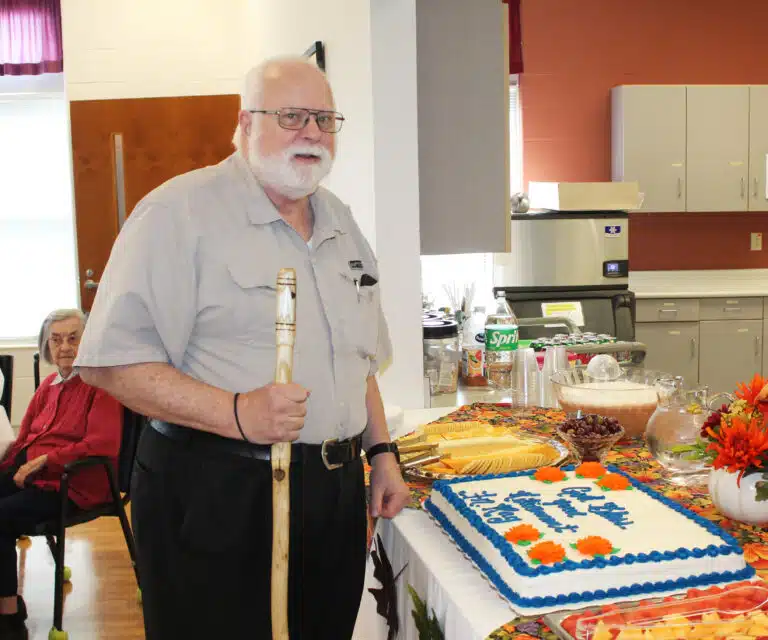 Father Ray gets ready to cut his retirement cake.