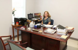 Jennifer Kaminski works at her new desk in Room 318 of Lourdes Hall on Monday, May 31. Wall hangings will go up soon.