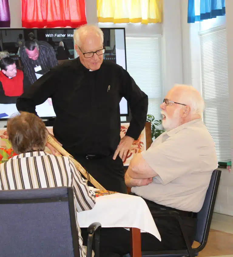Father John Vaughan, standing, came to celebrate Father Ray’s retirement.