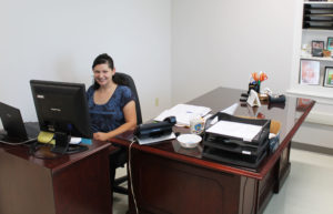 Kris Mango, communications and development specialist, works at her new desk in Room 315. Kris is the first person visitors will meet in the new offices as they come off the elevator.