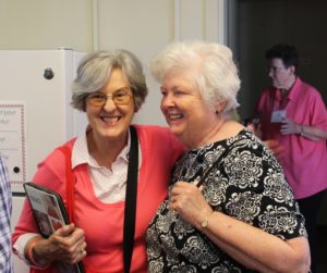 Associate Pauline Goebel, left, shares a smile with Sister Vivian Bowles in the registration line.