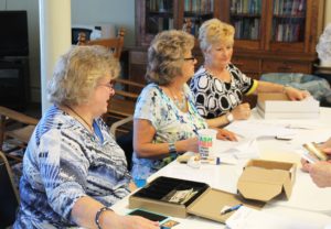 Associates Suzanne Reiss, left, Brenda Semar, center, and Carol Hill registered more than 100 sisters and associates for the day.