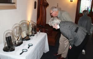 Guests look over these items that belonged to Father Volk. They were displayed in the Chapel gathering space.