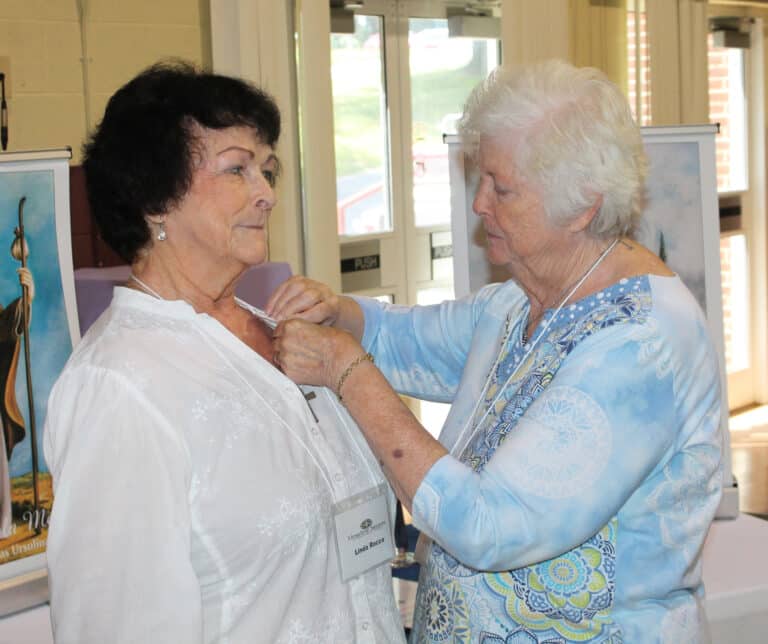 Sister Vivian Bowles places the Associate pin on Linda Rocco following the commitment ceremony. Sister Vivian was Linda’s contact Sister for formation.