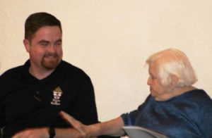 Corey Bruns, a seminarian for the Diocese of Owensboro, receives congratulations from Ursuline Sister Catherine Kaufman after it was announced that he won a contest to write the music for Hymn for the 100th Anniversary of Fr. Paul Volk’s Death.