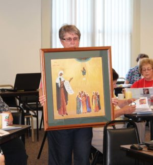 Sister Betsy Moyer begins the procession for the third vignette, “Mercy in the Life of Saint Angela and the Ursuline Vocation of Sister and Associate,” by carrying a picture of Saint Angela.