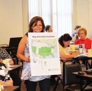 Associate Debbie Lanham carries a map that shows the 27 states and two foreign countries where Ursuline Associates live.