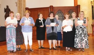 More of the 11 new associates read their commitment papers. From left are Doreen Abbott and Martha Warren, with their contact companion Sister Suzanne Sims; Martha Alle, with her contact companions Sister Amelia Stenger (left) and Sister Michael Ann Monaghan; Alisa Clark and Sherry Newton, with their contact companion Sister Pat Rhoten.