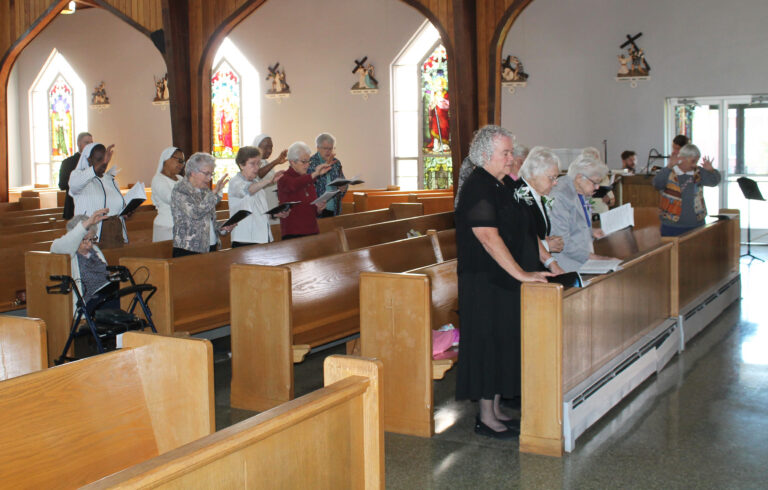 Sisters and Father Corey Bruns raise their hands to bless the jubilarians. Sisters and Father Corey Bruns raise their hands to bless the jubilarians.