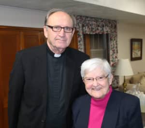 Father Harry Hagan, OSB, who wrote the lyrics to the Paul Volk hymn, visits with his cousin, Sister George Mary Hagan, during the reception after the concert.
