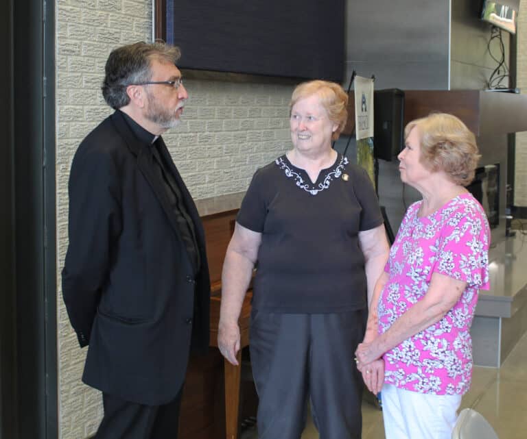 Sister Helena Fischer, center, and her sister Rose Hodgkins talk with Brescia President Father Larry Hostetter. Sister Helena is the registrar at Brescia and also lives with Sister Vivian.