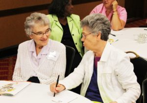 Ursuline Sisters Ann Patrice Cecil, left, and Nancy Murphy talk prior to the opening prayer service.