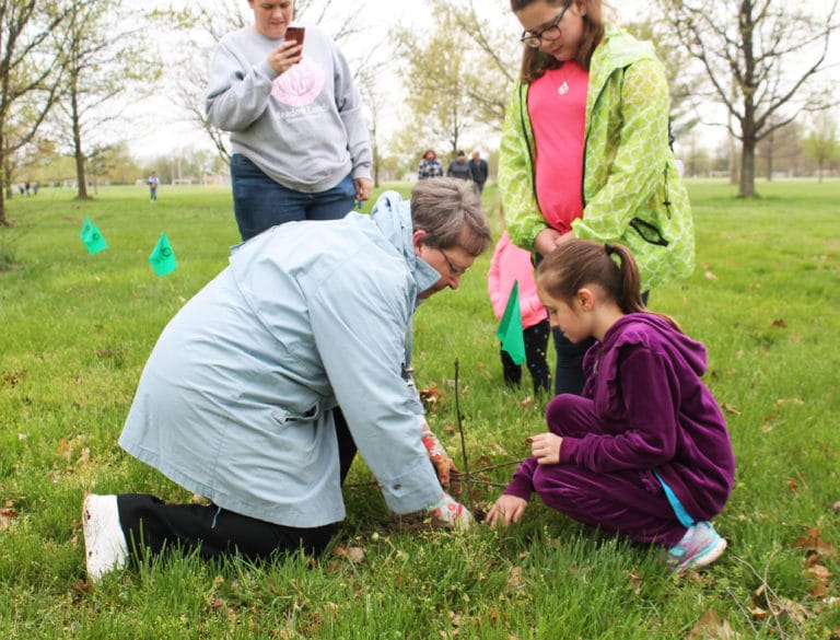 Sister Amelia Stenger shows a young lady the proper technique for planting a tree during a Community Arbor Day Event in 2019. The Ursuline Sisters supplied 500 trees for planting that day.
