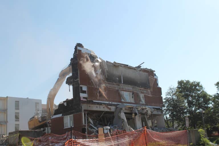 The excavator begins the final steps of removing Paul Volk Hall.