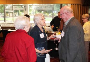 Sister Angela Fitzpatrick, center, and Sister Martina Rockers talk with Father Michael Crosby, one of the keynote speakers, at a reception July 7.