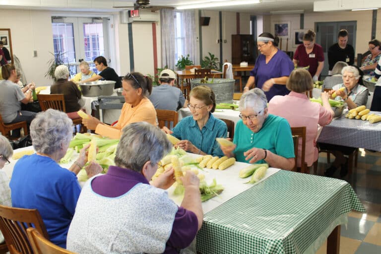 Sister Ruth Gehres, right, joins the shucking crew as the small dining room fills with Sisters, staff and supporters.