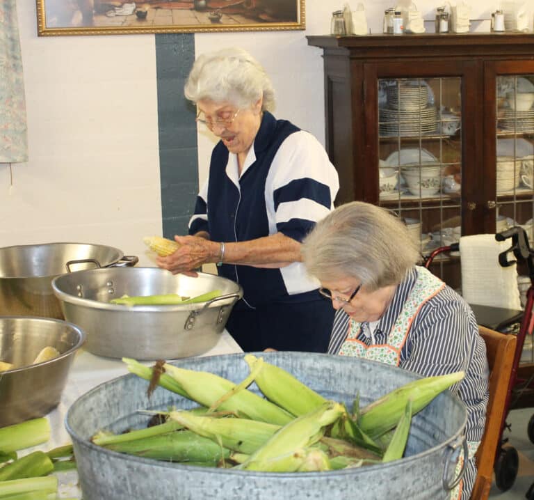 Sister Elaine Burke, left, finds something to laugh about as she and Sister Catherine Barber fill their buckets.