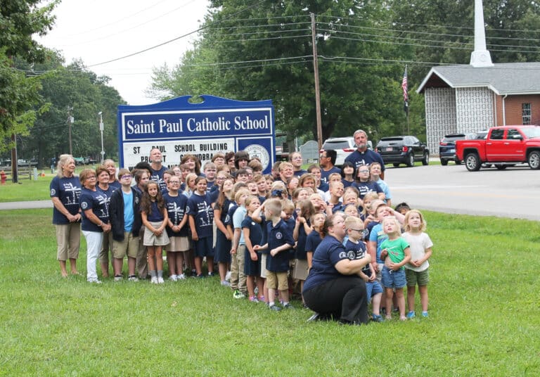 All 75 students at St. Paul Catholic School, along with their teachers, principal Todd Johnston (back left) and pastor Father Steve Hohman (back right) pose for a photo before the groundbreaking. St. Paul Church is in the background.