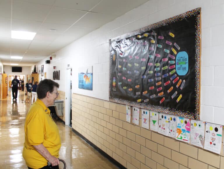 Sister Sharon Sullivan enjoys a bulletin board in St. Paul School with the names of all 75 students, along with the Mother Teresa quote, “I am a small pencil in God’s hand.”