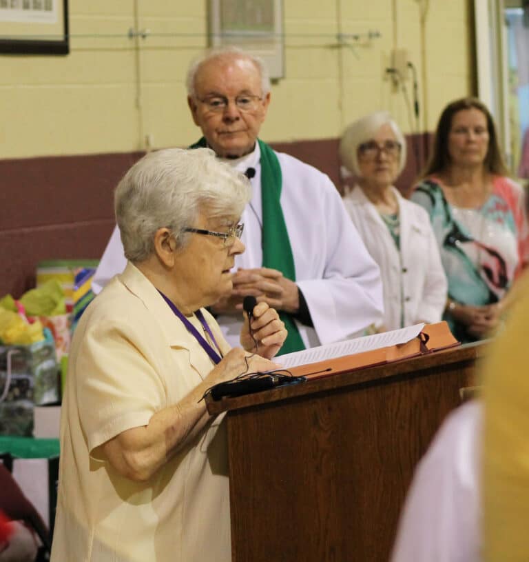 Sister Cecelia Joseph Olinger A’58, reads the intercessions, as Father Ed Bradley and the musicians look on.
