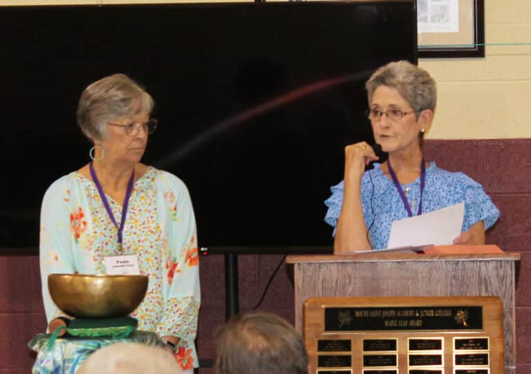 Stephanie Warren A’73, right, Alumnae Association president, and Paula Chandler Gray, A ’73, treasurer, read the names of the alumnae whose deaths have been reported in the past year.