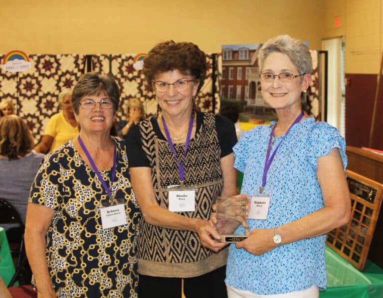 Sheila Ward A’71, center, accepts her Maple Leaf Award from her nominator, Rebecca Collins Morris A’71, left, and Stephanie Warren, Alumnae Association president.