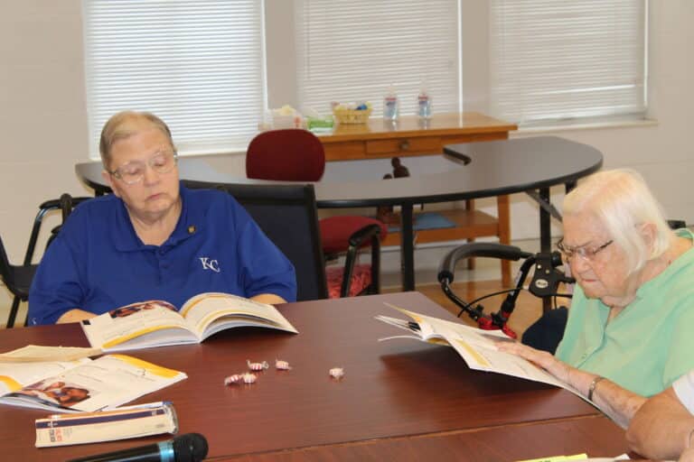 Sister Kathleen Dueber, left, and Sister Catherine Kaufman follow along in the Participant Guide provided by the Diocese of Owensboro.