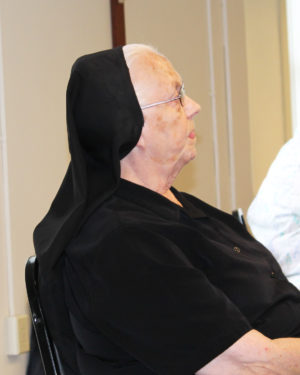 Sister Anne Michelle Mudd, who lives in Leitchfield, Ky., listens intently to Father Conley.