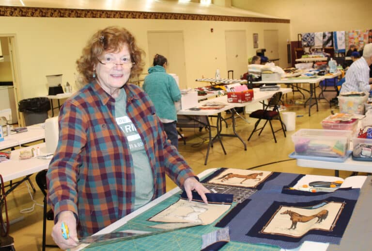 Jean Person works on cutting squares with horse patterns to add to a western-themed quilt top. She has been coming to the Quilting Friends for 20 years from her home in southwestern Tennessee.