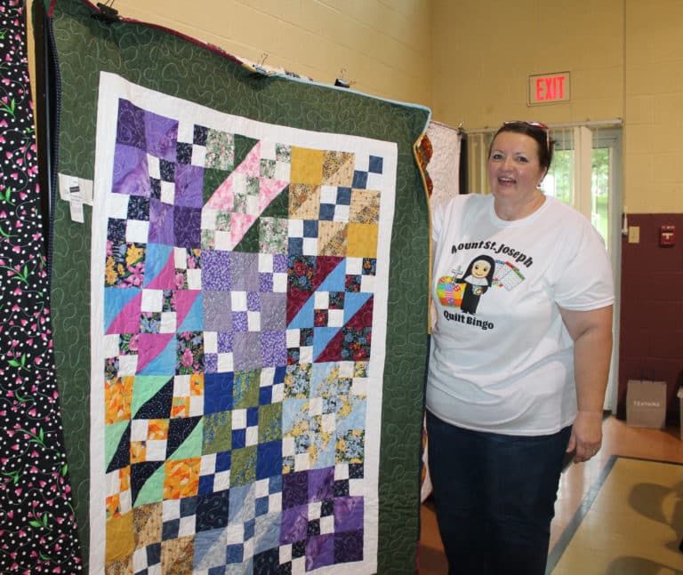 Mary Jane Tungate of Bradfordsville, Ky., shows off her prize, while sporting her homemade Quilt Bingo shirt.