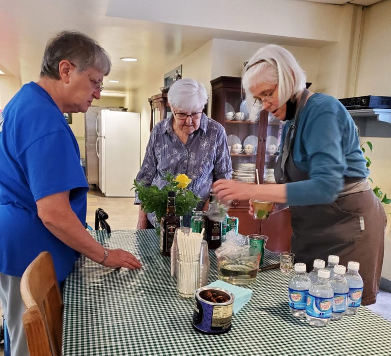 One can’t have a Kentucky Derby party without a mint julep. Sister Nancy Liddy, right, works on her technique under the watchful eyes of Sister Emma Anne Munsterman, left, and Sister George Mary Hagan.