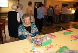 Sister Ruth Mattingly, seated at the jubilarian table, is celebrating her 60th jubilee year. Behind her, the sisters go through the buffet line.