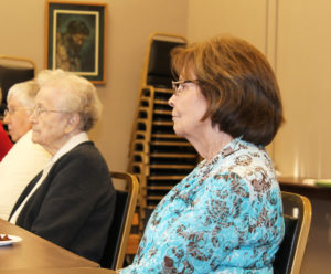 Nancy Howard, right, and Sister Alfreda Malone listen to Sister Vivian read a poem about loss called “Memories,” written by Ursuline Sister Grace Simpson.