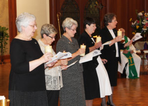 The 2016-22 Leadership Council reads from Saint Angela Merici’s First Counsel as they hold the candles passed onto them by the previous Council. From left are Councilor Sister Pat Lynch, Councilor Sister Judith Nell Riney, Councilor Sister Pam Mueller, Assistant Congregational Leader Sister Kathleen Condry and Congregational Leader Sister Amelia Stenger.