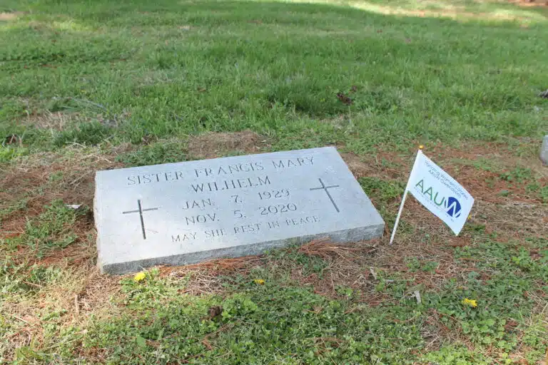 Sister Fran Wilhelm’s grave receives a flag on her headstone. Sister Fran helped found Centro Latino to aid migrants and refugees in Owensboro.