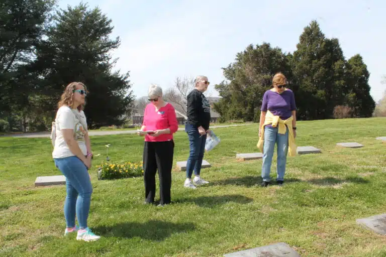 Sagan Storm, Judy Adams, Debbie McCoy and Aloma Dew search for a Sister’s headstone. Dew serves as the AAUW historian.