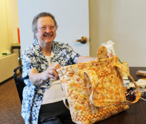Pat Turner holds up one of the purses she’s working on that will be sold at auction to raise money for her mission work.