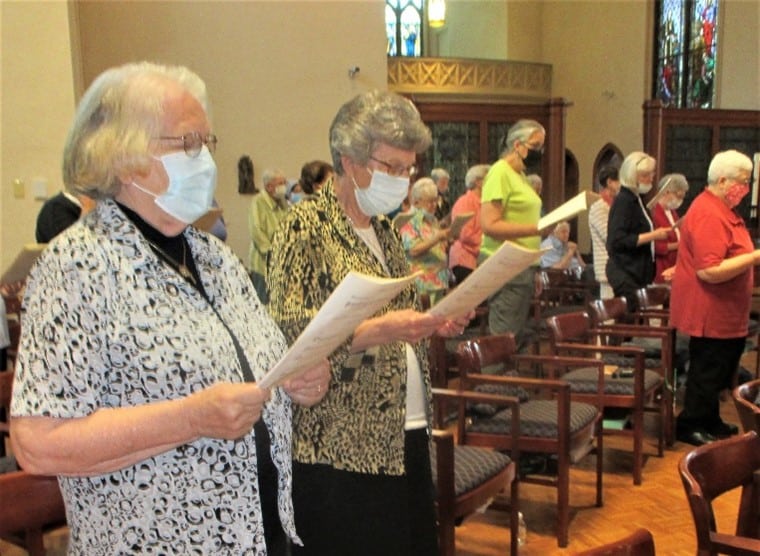 Sister Rosanne Spalding, left, and Sister Margaret Ann Aull join in the singing at Mass.
