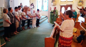 Father Darrell Venters, pastor of St. Jerome Church, gives a blessing to the mission team during Mass on Sept. 18, as the parishioners join in.