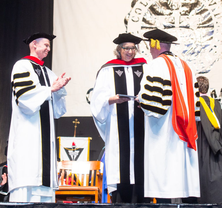 Ursuline Sister Larraine Lauter receives her honorary doctorate in divinity from the Rev. Brian J. Shanley, O.P., president of Providence College. At left is the Very Reverend Kenneth R. Letoile, O.P, Prior Provincial of the Province of St. Joseph.