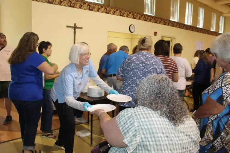Sister Nancy Liddy hands out paper plates to those waiting in the lunch line. Sister Nancy Liddy hands out paper plates to those waiting in the lunch line.
