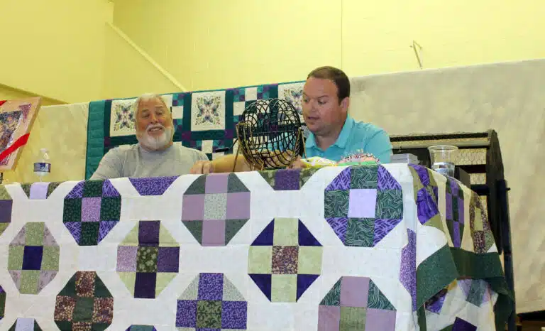 Charlie Shelton, a former Mount Saint Joseph employee, calls bingo numbers at right as Bruce Tucker, a volunteer from Precious Blood, keeps track of the numbers. Charlie Shelton, a former Mount Saint Joseph employee, calls bingo numbers at right as Bruce Tucker, a volunteer from Precious Blood, keeps track of the numbers.