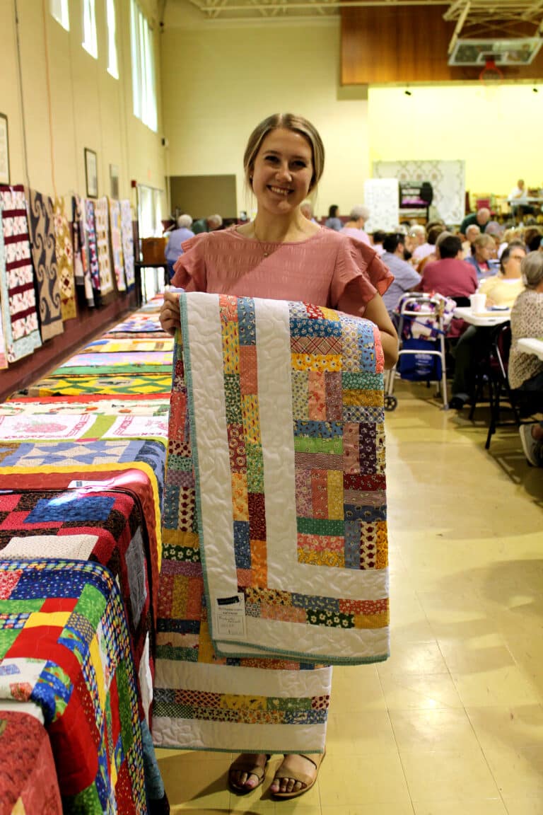 Courtney Carpenter of Owensboro holds the “Grandmother’s Railroad” quilt after winning a bingo game.