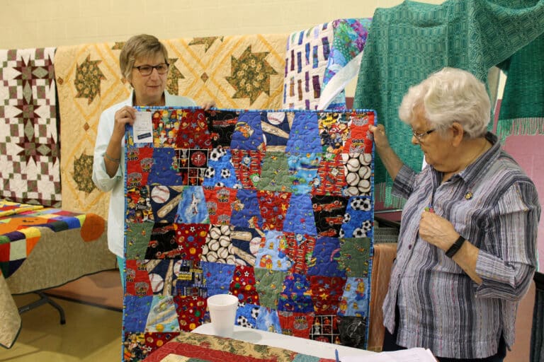 The “I Spy” children’s quilt was the selection of Donna Goetz of Owensboro. Sister Cecelia Joseph Olinger at right looks at the quilt.