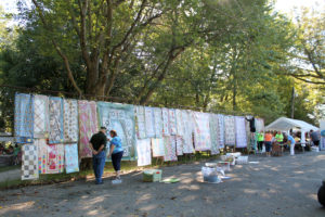 Visitors look over all of the quilts for sale at the Mount Saint Joseph Picnic.
